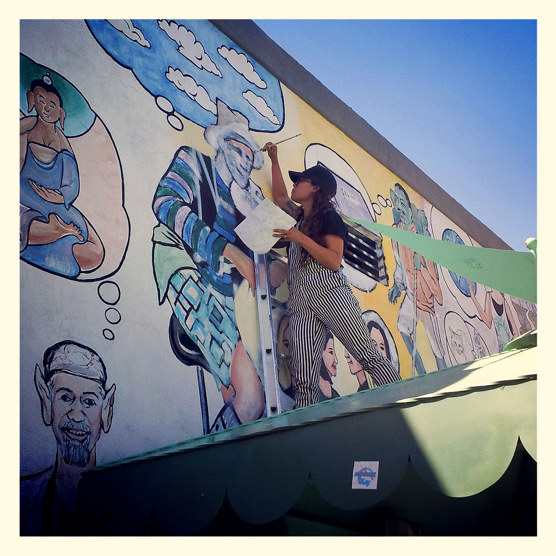 Artist Allison Miller painting a mural