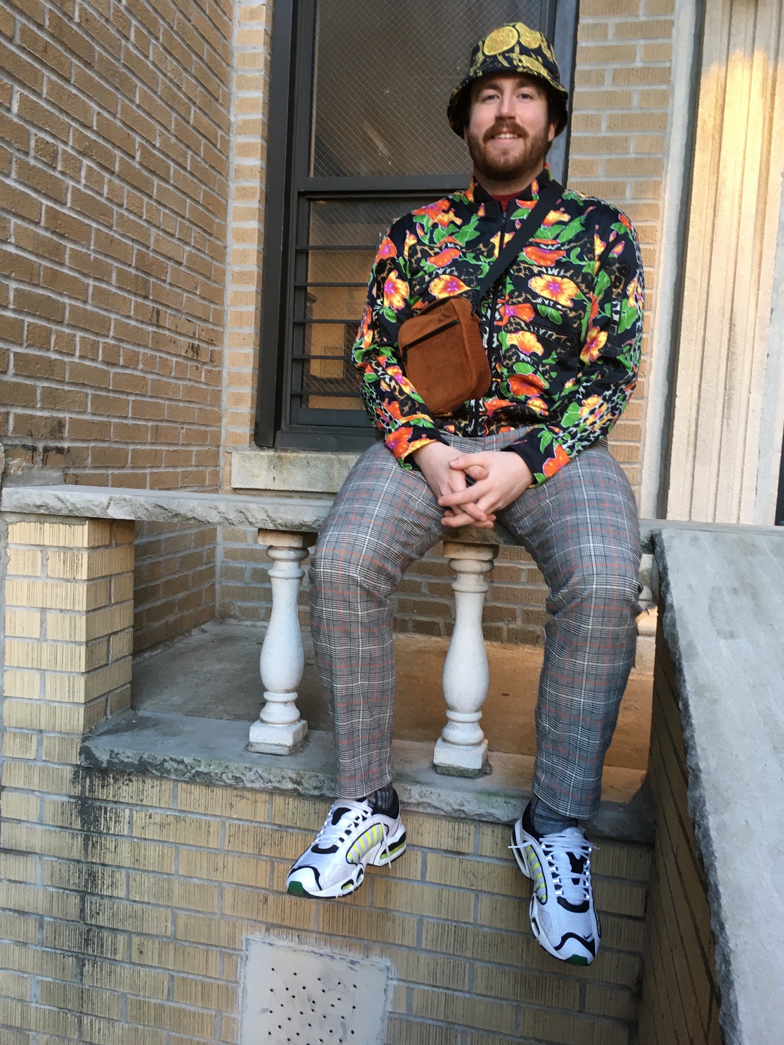 Man wearing a fall outfit accessorizing with a hat and a mini bag