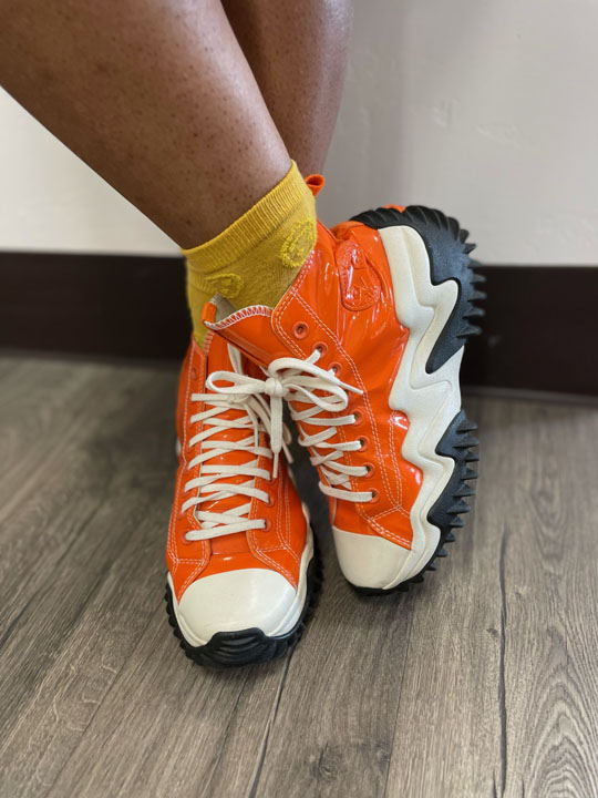 Close up of person wearing bright orange platform converse sneakers