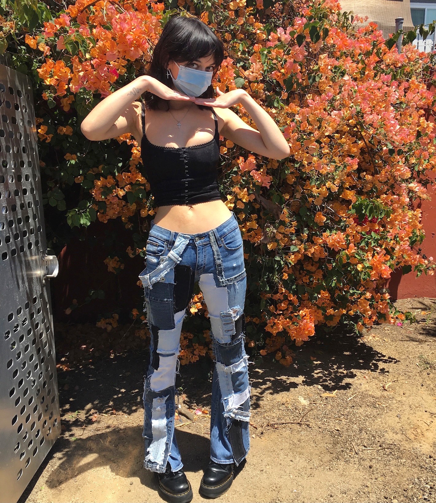 girl wearing low-rise patchwork jeans and a black corset tank top