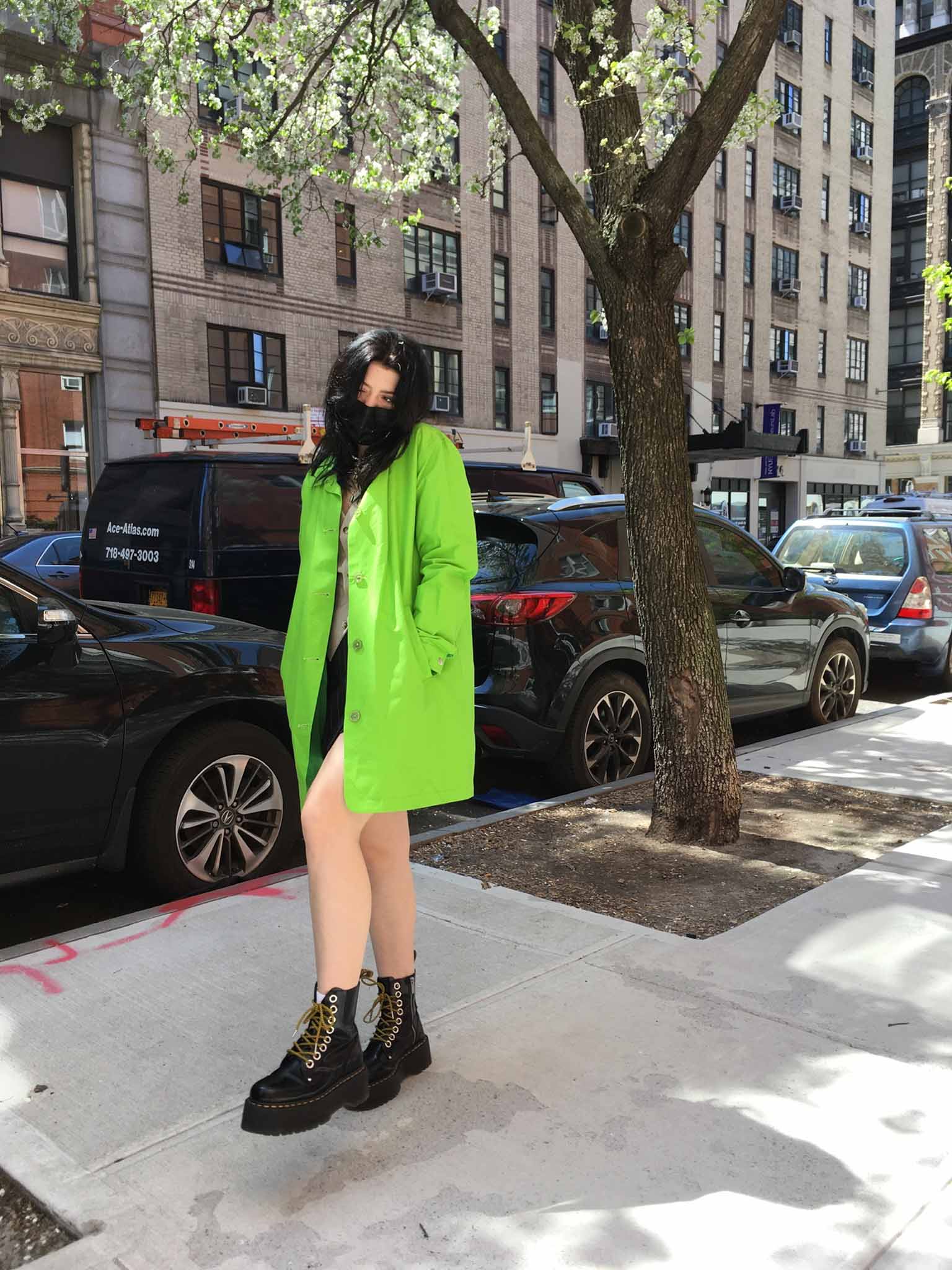 person walking on neighborhood sidewalk in New York City wearing platform Dr.Martens boots and oversized neon green blazer