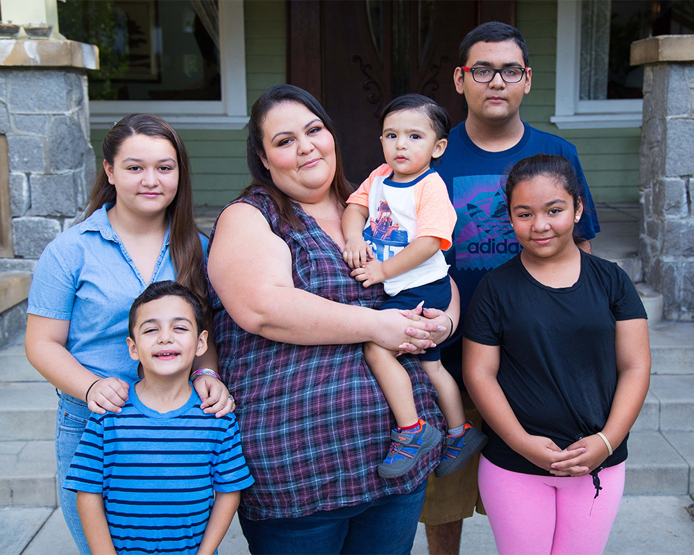 A Alexandria House family in front of a house