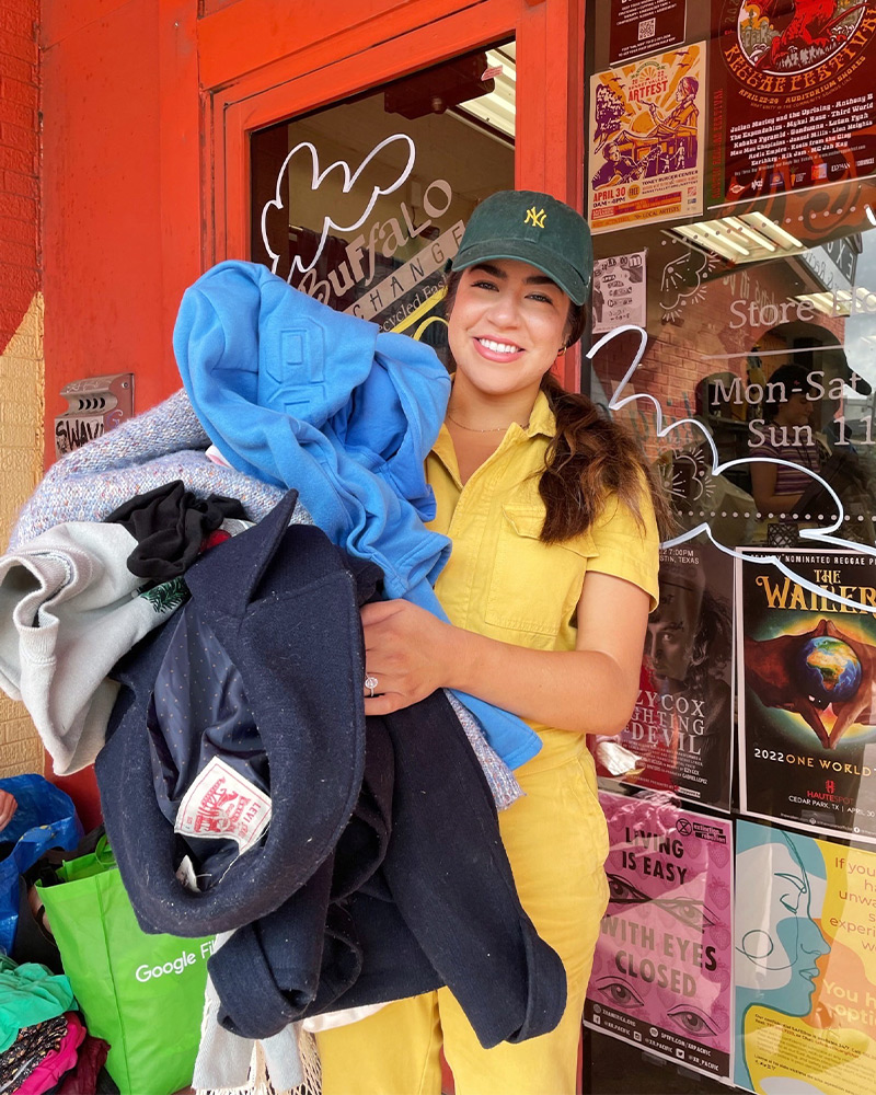 $1 sale shopper holding a bundle of clothes