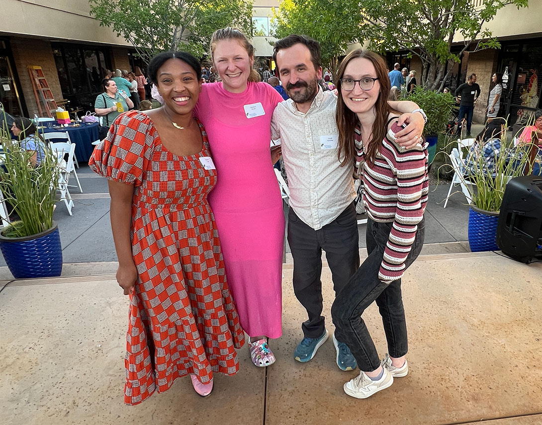 4 people posing at Community Impact Night event