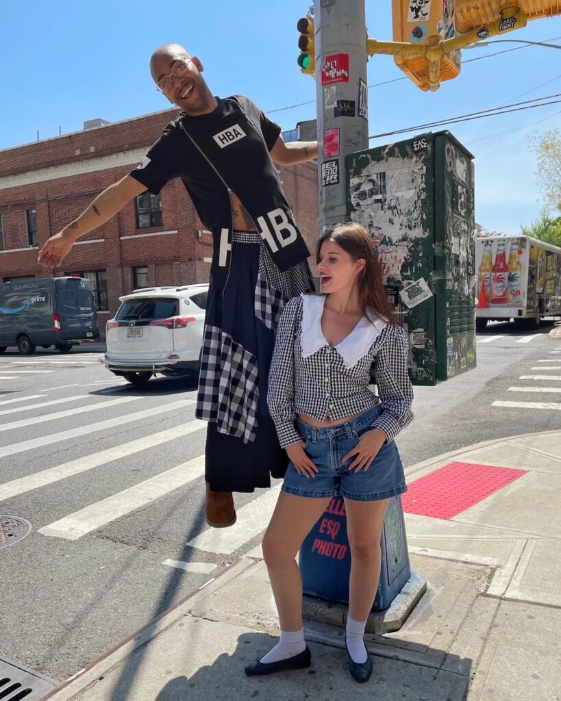 2024.05.10. NY01 Two people standing at a crosswalk wearing monochromatic outfits with gingham plaid
