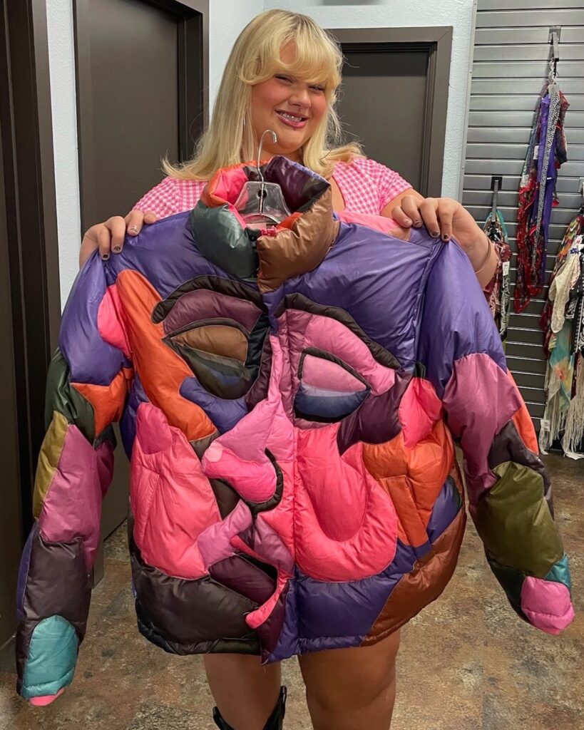 2024.07.05 NV1 (1) Person holding KidSuper pink and purple quilted puffer jacket